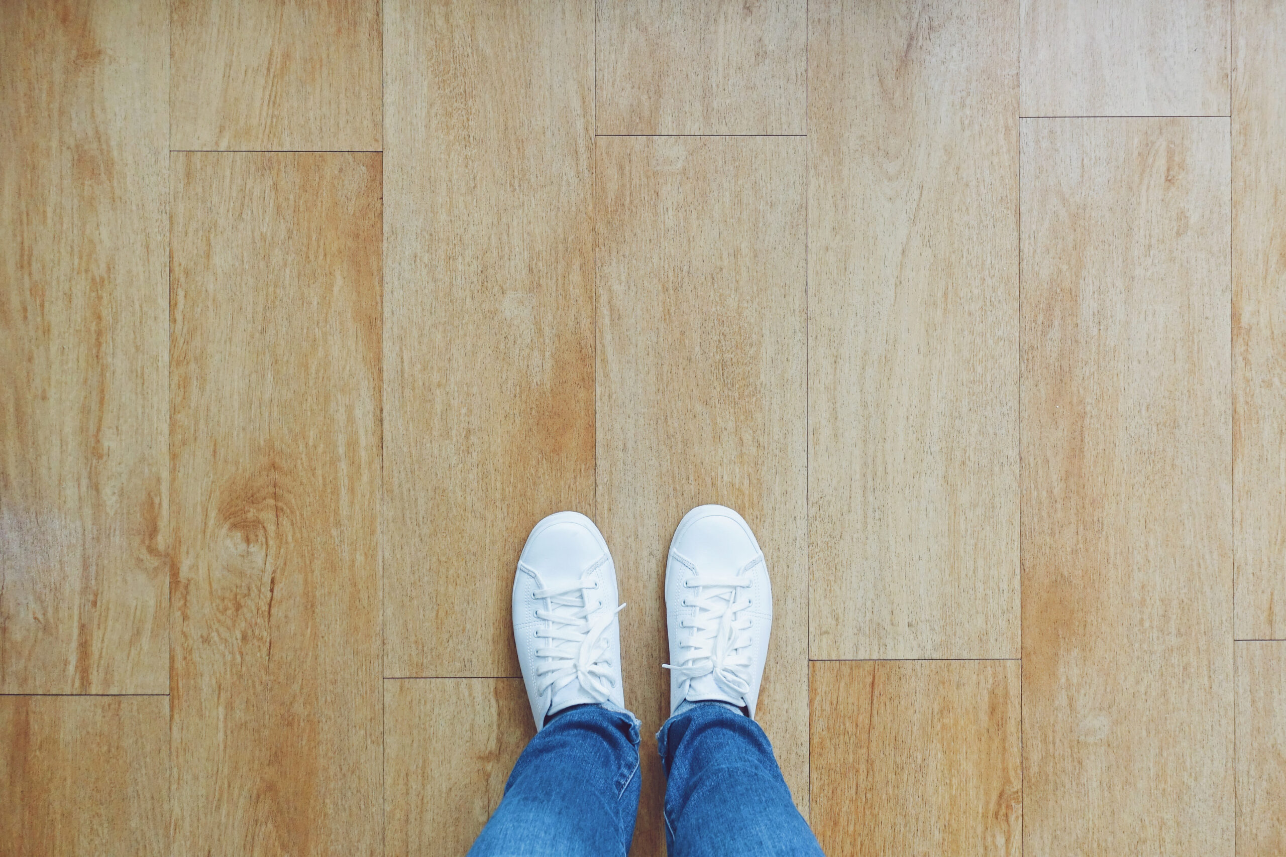 Selfie of feet in fashion sneakers on wooden floor background, t